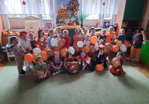 Dzieci z balonami przebrane w stoje o tematyce jesiennej