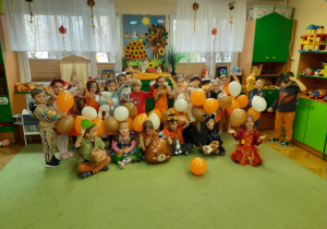 Dzieci przebrane w kolory jesieni pozują z balonami