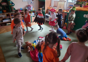 Dzieci przebrane w kolory jesieni tańczą w kole