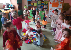 Dzieci przebrane w kolory jesieni tańczą w kole