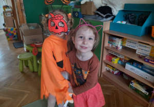 Dwoje dzieci ubranych na pomarańczowo tańczy
