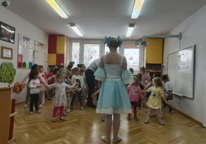 Tancerka pokazuje dzieciom układ taneczny