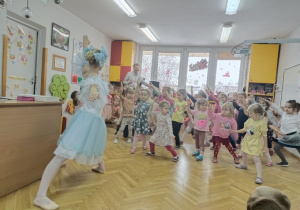 Tancerka pokazuje dzieciom układ taneczny