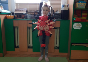 Dziecko trzyma dużego pająka wydrukowanego na drukarce 3D