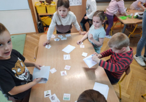 Dzieci przy stoliku układają obrazki w pary