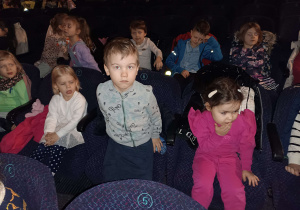 dzieci siedzą na fotelach w teatrze