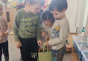 dzieci częstują się cukierkami z torebki którą trzyma chłopiec