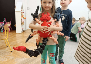 dziecko trzyma wielkiego skorpiona wydrukowanego na drukarce 3D