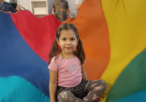 dziewczynka siedzi na kolorowej chuście