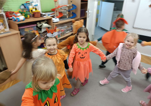 dzieci ubrane w kolory jesieni tańczą w kole