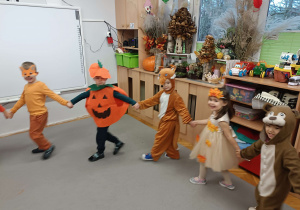 dzieci ubrane w kolory jesieni tańczą w kole