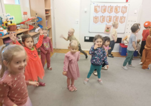dzieci ubrane w kolory jesieni tańczą na dywanie