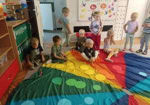 dzieci układają kółka na kolorowej chuście