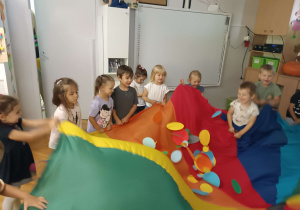 dzieci układają kółka na kolorowej chuście
