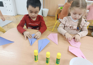 dzieci składają papier przy stoliku