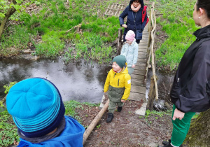 Dzieci przechodzą przez drewniany mostek