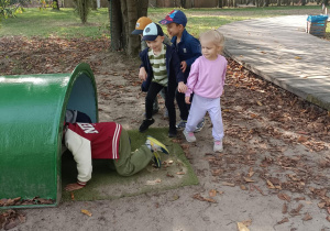 dzieci wchodzą do zielonego tunelu
