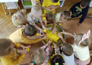 dzieci ubrane na żółto lepią z żółtej masy solnej