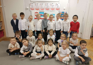 dzieci stoją przed tablicą z napisem Polska
