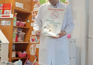 pszczelarz prezentuje nabierak do miodu