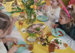 dzieci siedzą przy świątecznie nakrytym stole