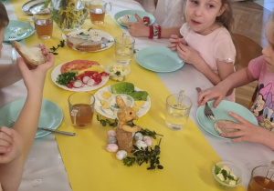 dzieci siedzą przy świątecznie nakrytym stole