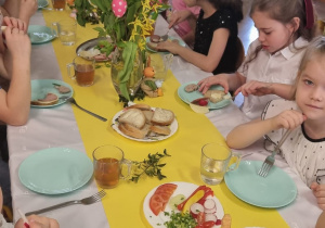 dzieci siedzą przy świątecznie nakrytym stole