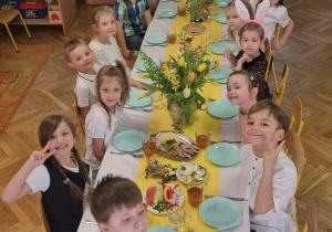 dzieci siedzą przy świątecznie nakrytym stole