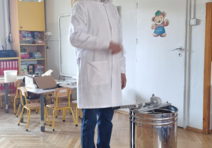 pszczelarz pokazuje jak działa wirówka do miodu