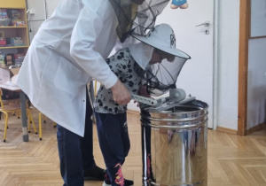 dziecko w kapeluszu ochronnym pszczelarskim
