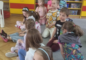 dzieci siedzą na dywanie