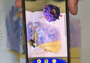 ekran telefonu pokazujący obraz 3d z okładki książki Mały książę