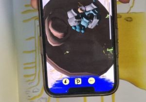 ekran telefonu pokazujący obraz 3d z okładki książki Mały książę