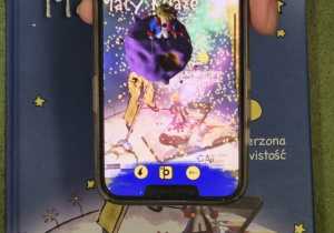 ekran telefonu pokazujący obraz 3d z okładki książki Mały książę