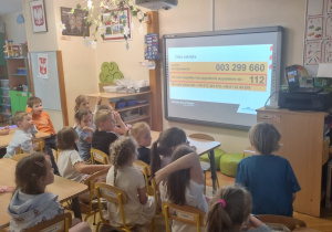 dzieci oglądają film o bezpieczeństwie na przejeździe kolejowym