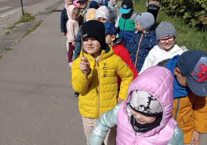 dzieci w paracz stoją na chodniku