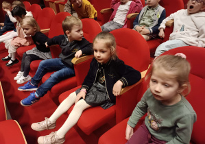 dzieci siedzą na fotelach teatru